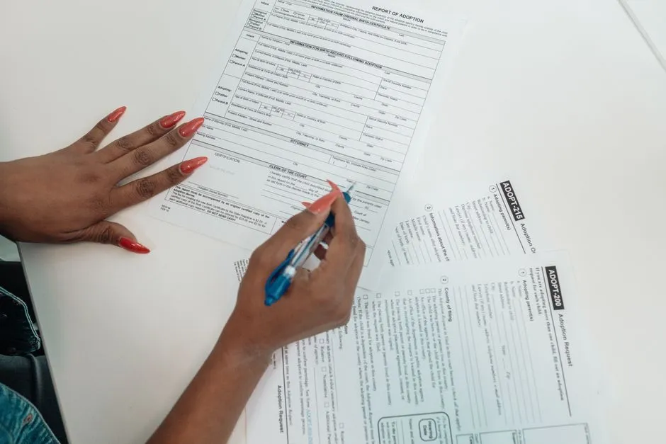A person filling out a paper application form, illustrating the kind of pre-application paperwork a Section 8 waitlist requires